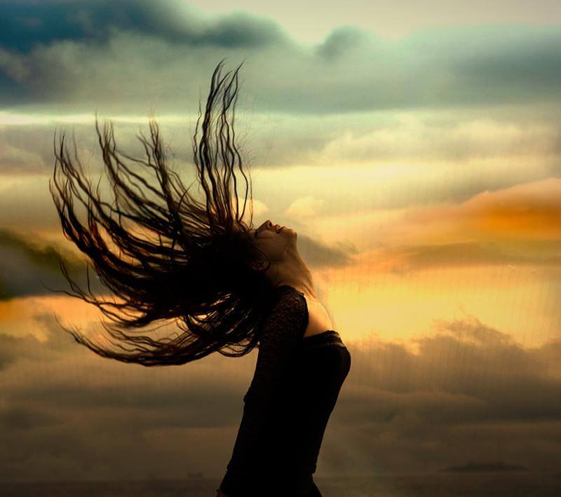 chica-mirando-hacia-arriba-con-cabello-al-viento