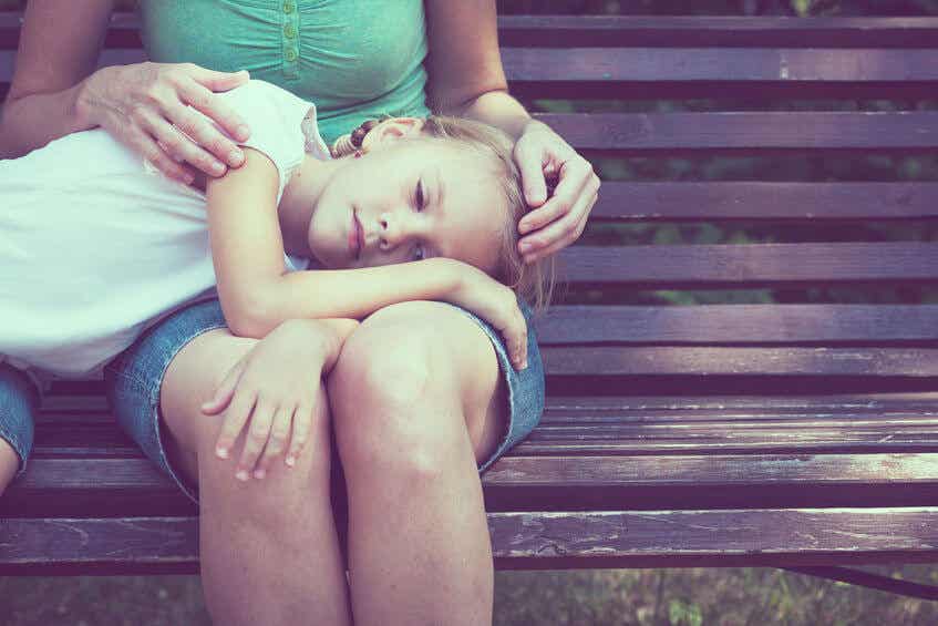 Hija triste con la cabeza apoyada en las piernas de su madre