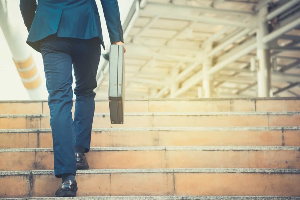 Hombre con portafolio subiendo escaleras
