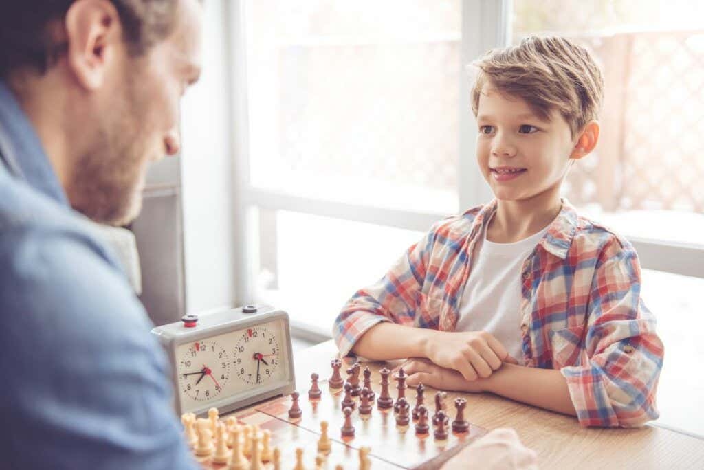 hombre jugando ajedrez con hijo