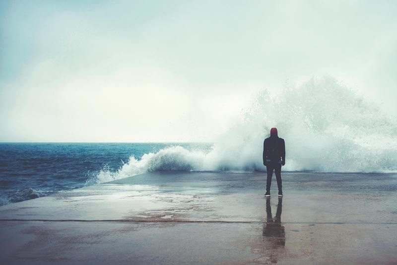 Hombre enfrente de un mar bravo