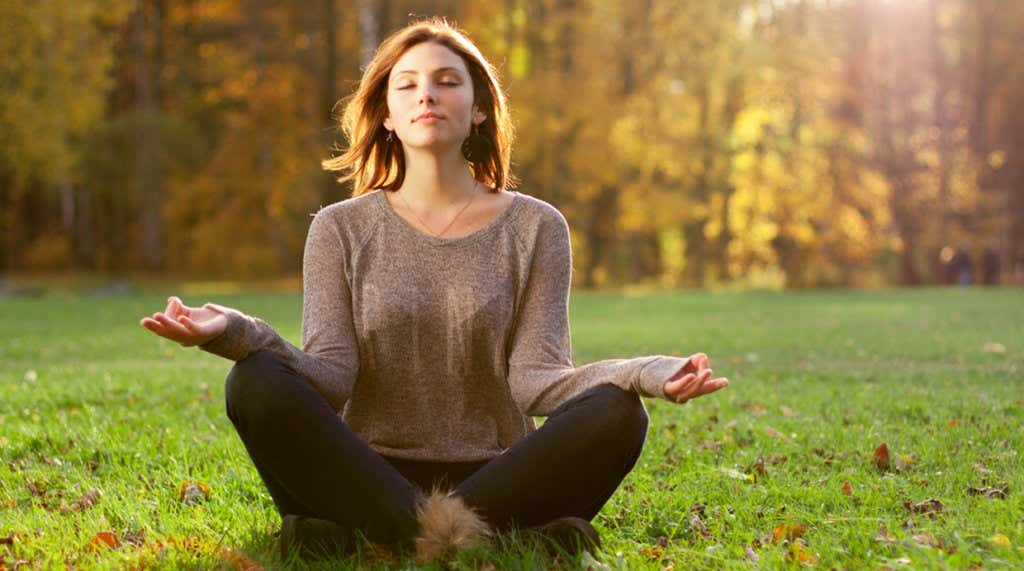Donna che medita con una delle tecniche di rilassamento per alleviare lo stress.