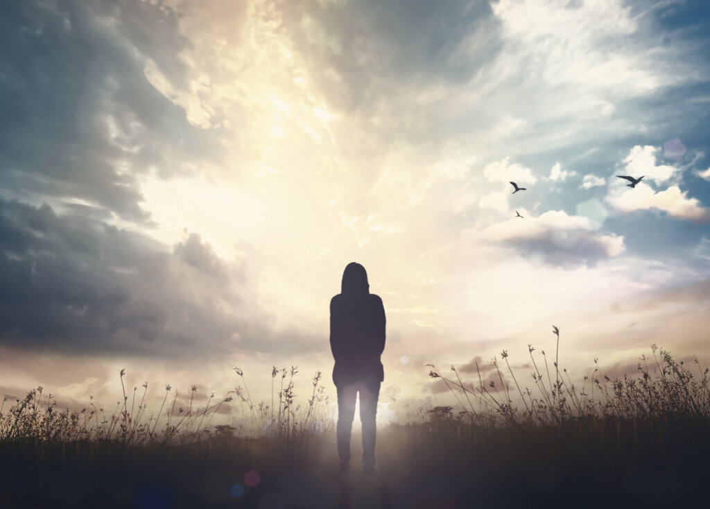 girl standing before light representing the archetype of the magician