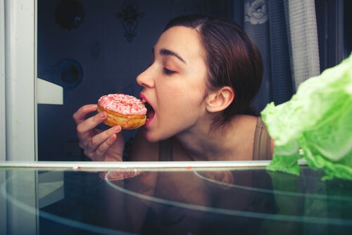 Mujer comiendo pasteles que afectan su cerebro