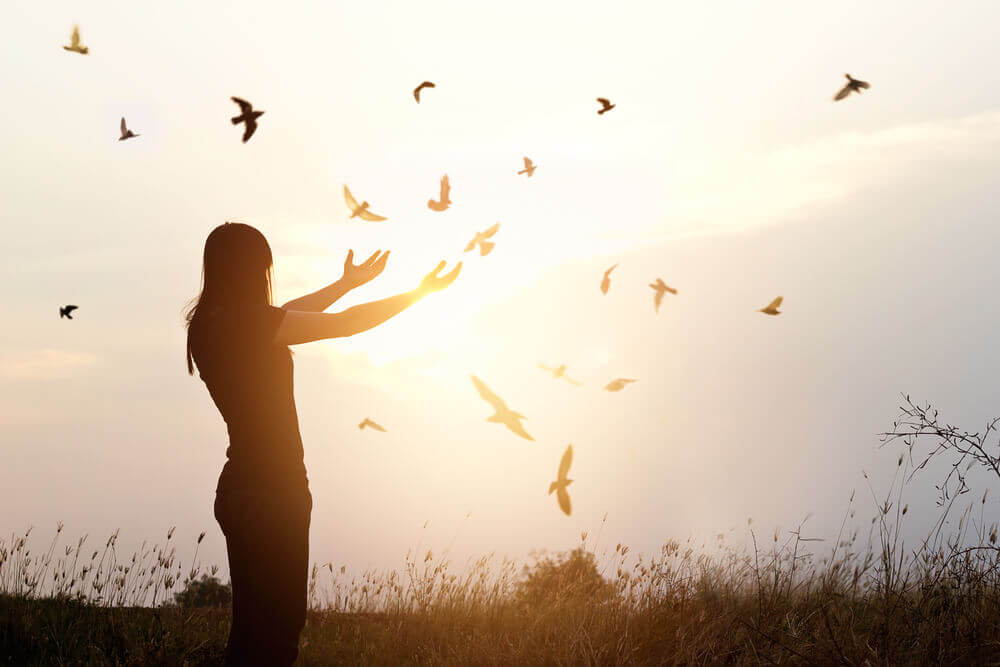 Mujer con pájaros volando