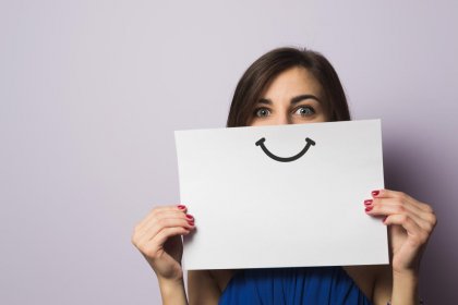 Mujer con sonrisa pintada en un papel