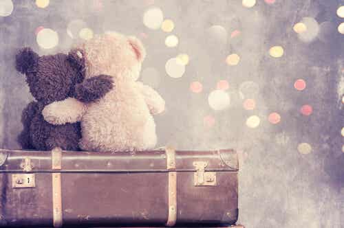 Teddyberen knuffelen elkaar bovenop een koffer