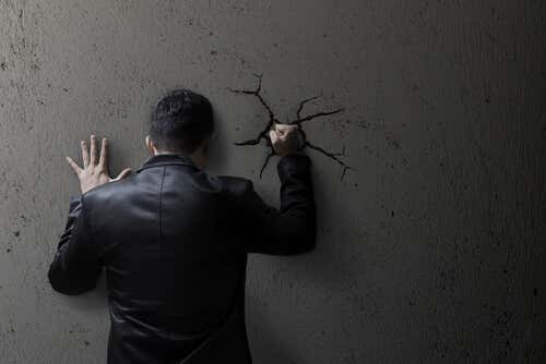 Hombre con trastornos psicológicos golpeando una pared