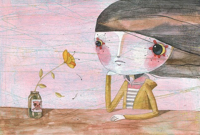 Niña triste mirando una flor