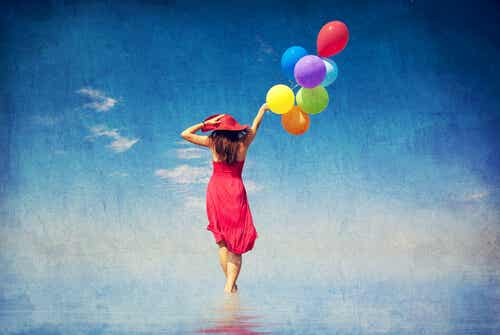 Mujer andando sobre el mar con globos de colores