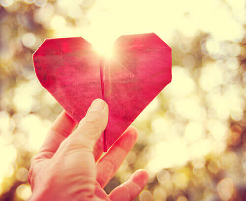 Sujetar un corazón de papel con una mano