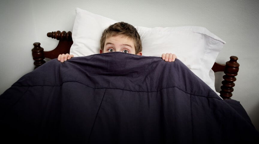 Niño con miedo en cama