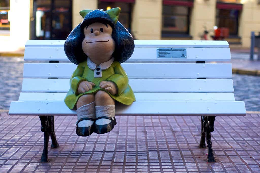 Mafalda sentada en un banco