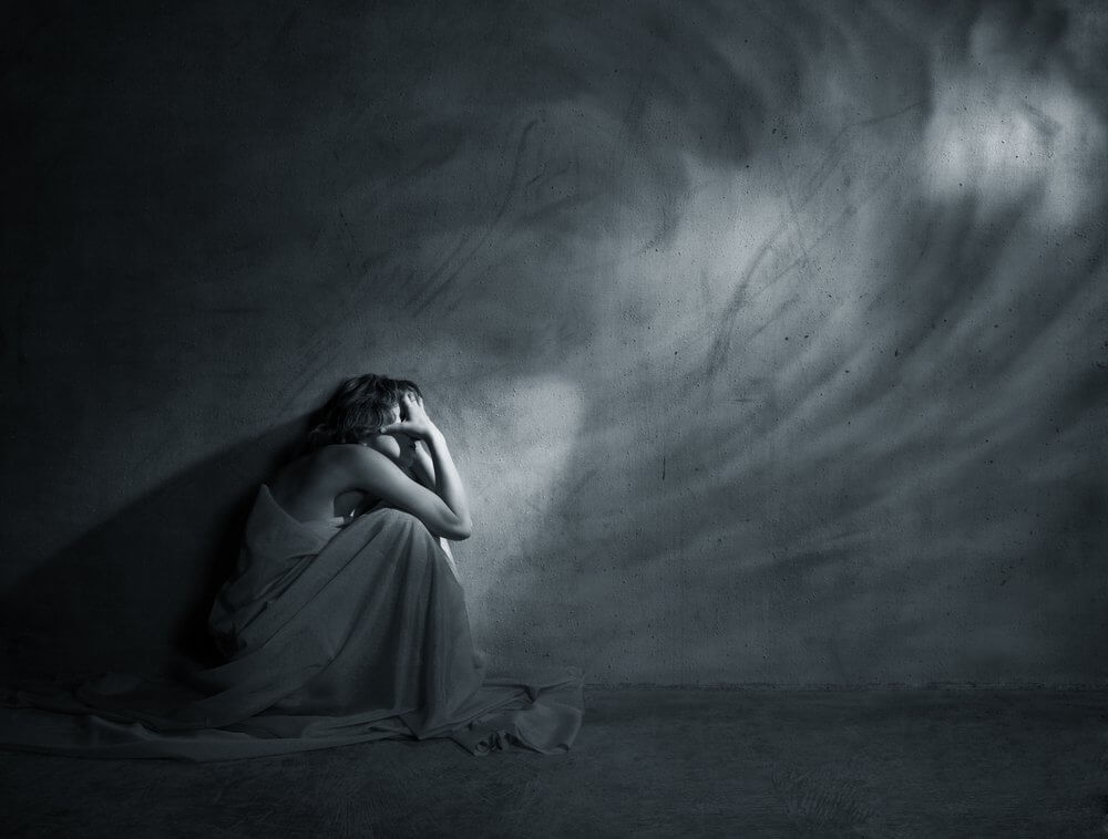 Mujer triste al lado de la pared