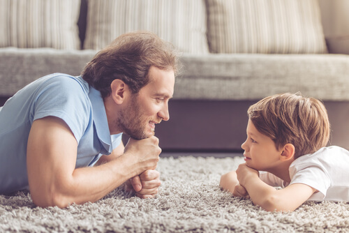 Padre mirando a su hijo a los ojos feliz por no educar con gritos