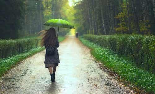 Mujer paseando con paraguas pensando que «podría ser peor» 