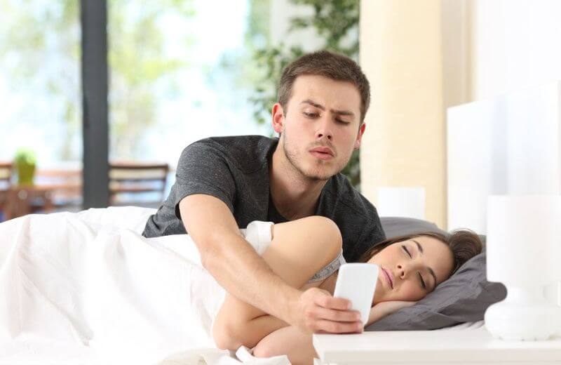 Hombre mirando el móvil de su pareja