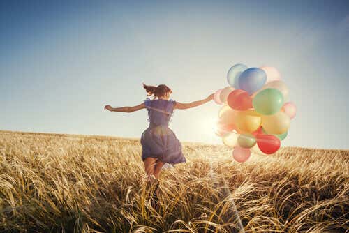 Mujer con globos feliz y demsotrando inteligencia emocional
