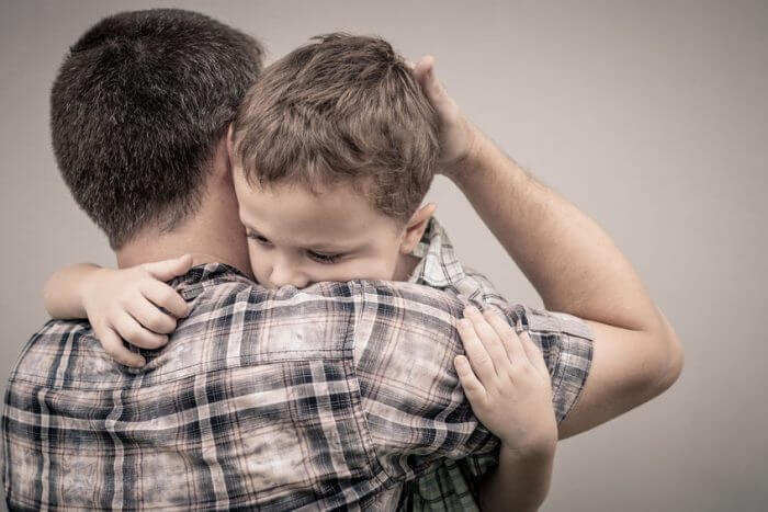 Padre sobreprotegiendo a su hijo simbolizando la sobreprotección
