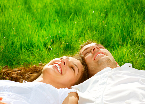 Pareja sonriendo en el cesped