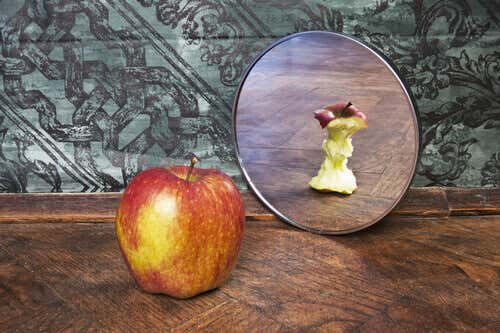 Manzana con complejos mirándose a un espejo