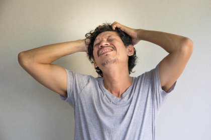 Hombre con un trastorno psicológico y las manos en la cabeza