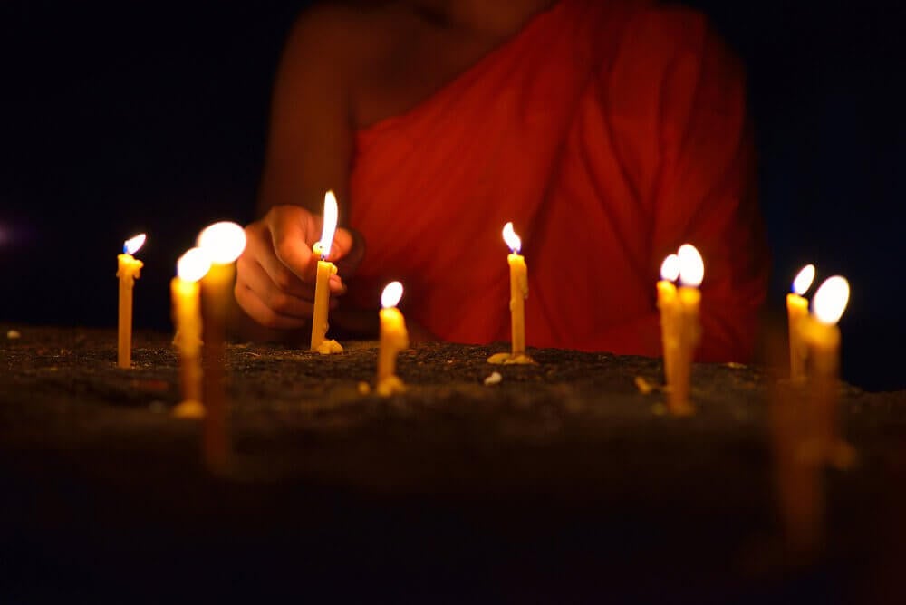 maestro budista encendiendo velas