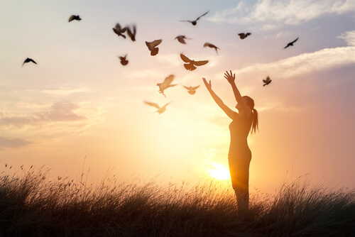 Mujer soltando pájaros que significan remordimientos