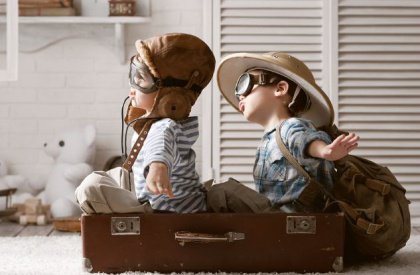 Niños jugando dentro de una maleta