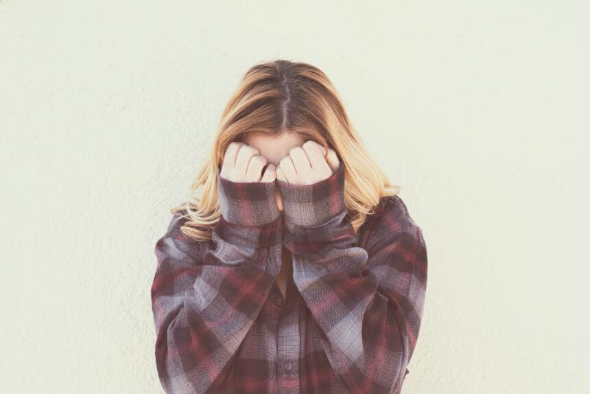 Mujer tapándose con timidez simbolizando la comunicación pasiva