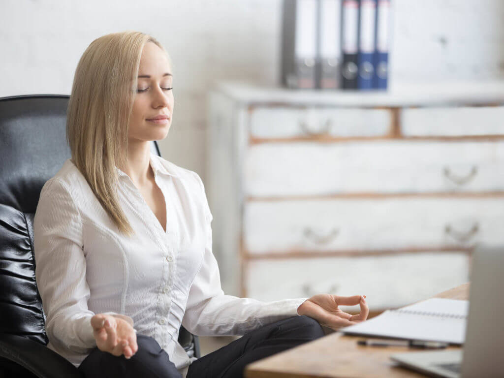 Mujer relajándose en el trabajo por el entrenamiento de inoculación de estrés