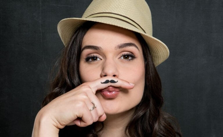 Chica con bigote pintado representando a un amigo que no lo es