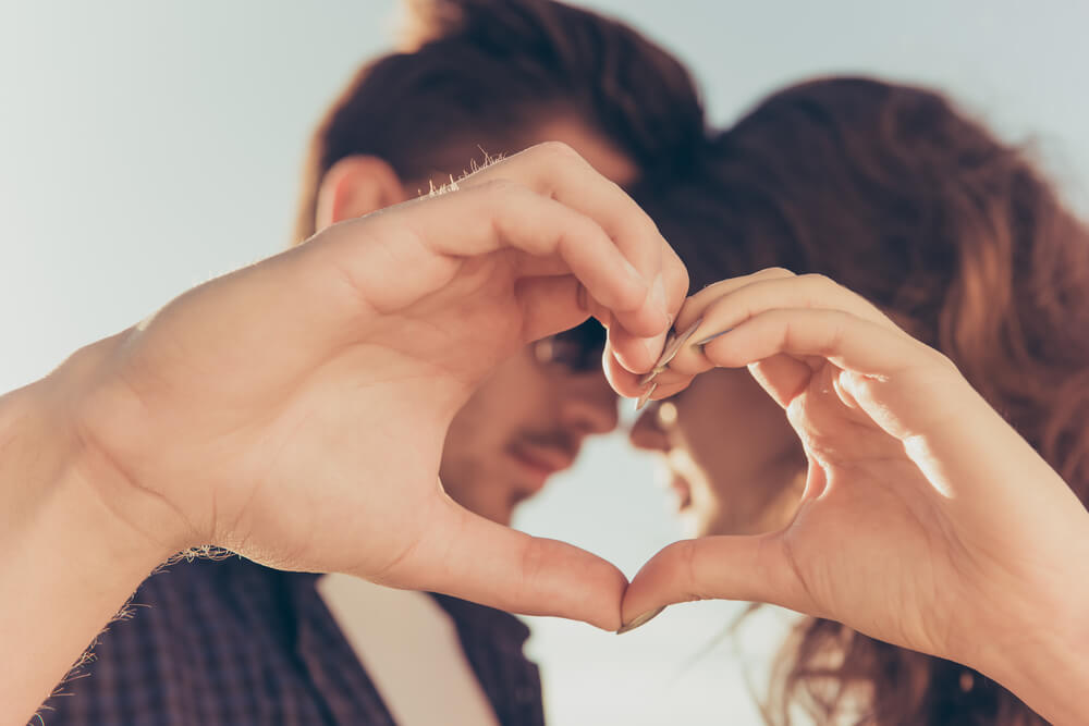 Pareja haciendo un corazón tras sentir amor a primera vista