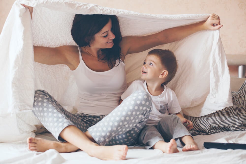 Madre con su hijo bajo una sábana