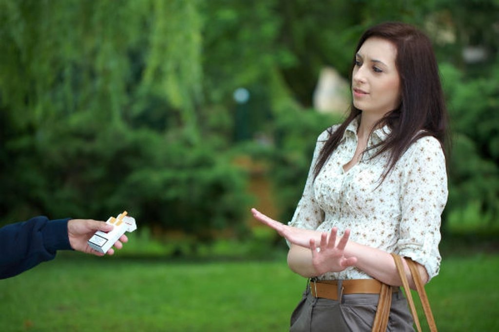 Femme refusant de prendre une cigarette symbolisant la peur de ce qu'ils diront