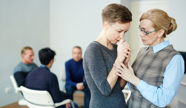 Mujer siendo consolada por su psicóloga