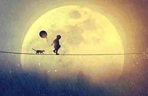 Niño caminando con un globo y un gato por una cuerda cerca de la luna