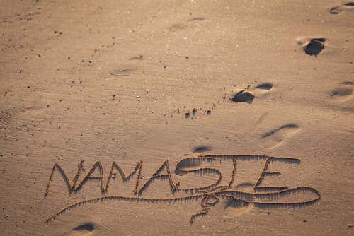 Parola Namaste scritta nella sabbia.