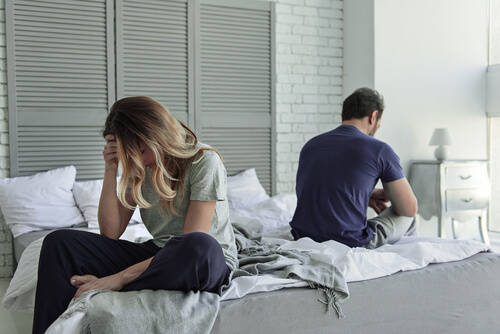 Pareja dándose la espalda en la cama y simbolizando que una relación necesita más compromiso y menos sacrificios