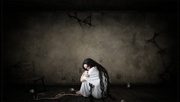 Mujer triste sentada en el suelo encogida