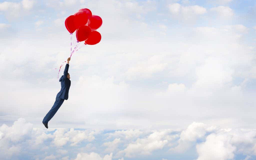 Hombre volando con globos