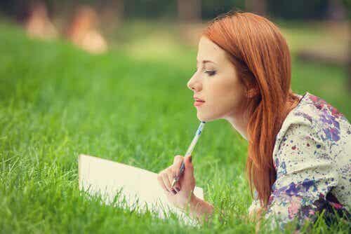 Mujer escribiendo sobre autoconocimiento en su diario
