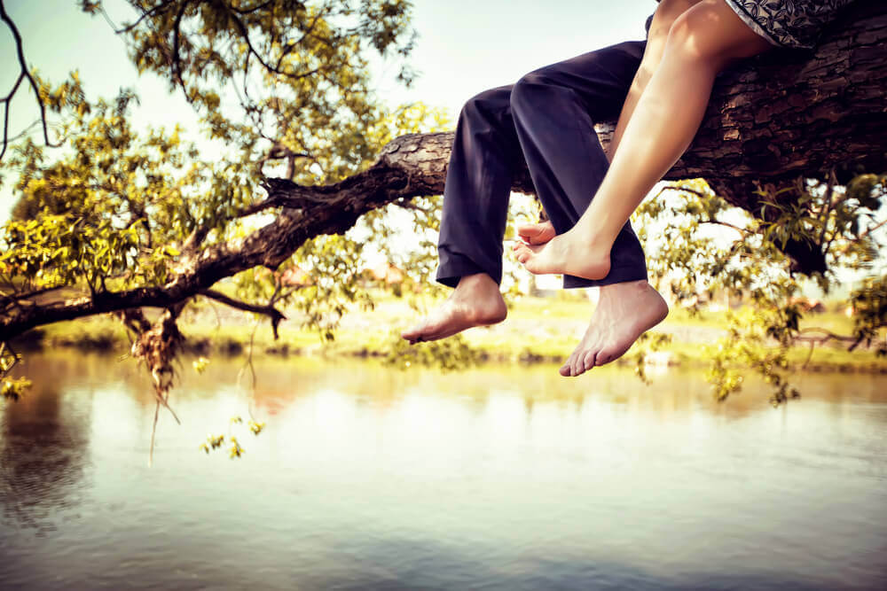 Pareja subida a un árbol simbolizando los conflictos más comunes en las parejas
