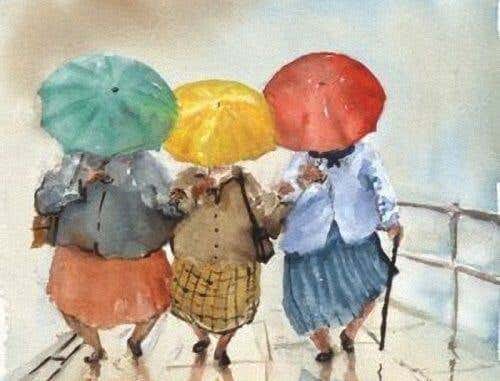 Tres mujeres con paraguas agarradas de las manos