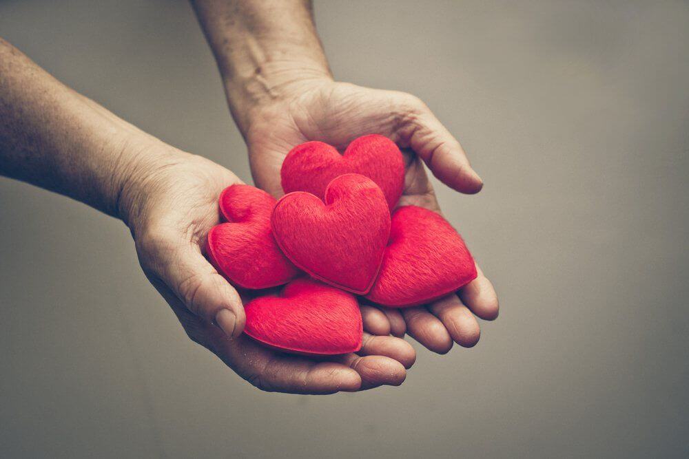 Manos sosteniendo corazones