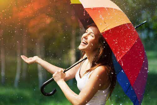 Mujer con paraguas de colores que conoce las enseñanzas de Albert ellis
