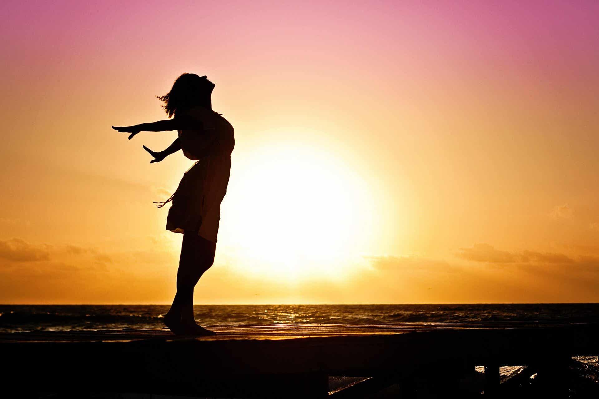 Kvinde danser foran solnedgang