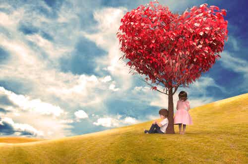 Chico sentado debajo del árbol del amor y chica de pie esperando