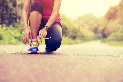 Mujer atándose una zapatilla para correr una maratón