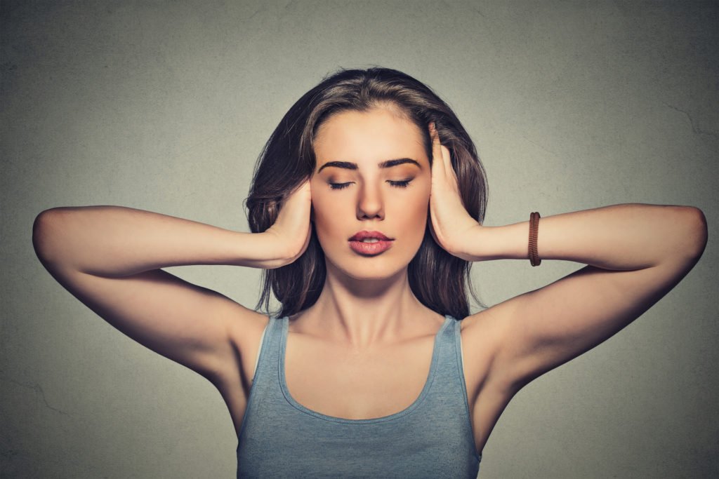 Mujer tapándose los oídos